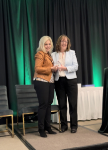 Rose Oswald Poels (right) accepts award from Michelle Vetterkind (left)